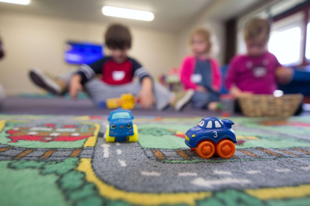 Children playing on a mate. Southend Childcare Services.